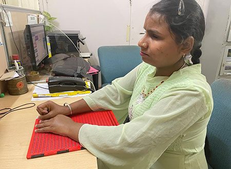 blind woman of nab center using braille